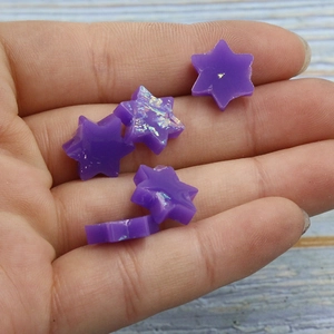 Macro shot of purple David Star synthetic opal charms with glitter for jewelry DIY