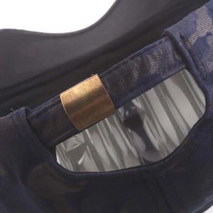 Detail of dark blue camo baseball cap showing adjustable bronze metal buckle and canvas texture