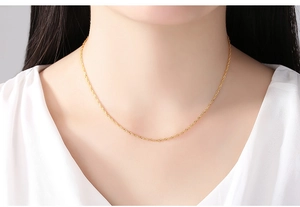 Detail of 14K gold plated water wave chain necklace worn on a model's neck