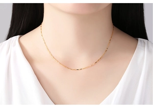 Close-up of a 14K gold-plated water wave chain necklace worn by a female model
