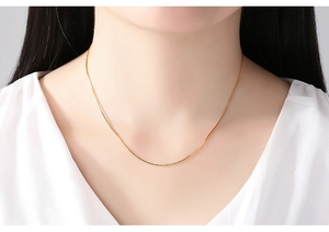 Elegant 14K gold plated water wave chain necklace worn by a model in a close-up shot