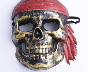 Detailed view of bronze pirate skull mask with red bandana and textured finish