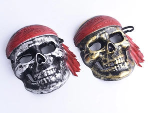 Detailed close-up of retro skull pirate masks in antique gold and silver with red bandanas