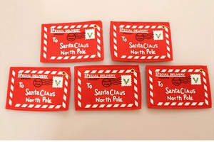 Close-up of five felt Christmas envelope gift tags with red and white festive patterns