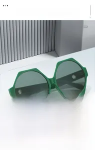 Detailed view of irregular hexagonal sunglasses with bright green frames on a geometric stand