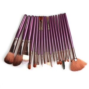 Detailed fan arrangement of 18 purple makeup brushes with rose gold ferrules on white background