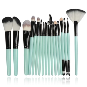 Macro shot of 16-piece mint green makeup brushes set with black and white fiber bristles