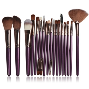 Macro shot of 16 professional makeup brushes with purple handles and rose gold ferrules