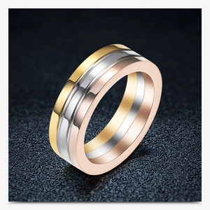 Macro detail of 6mm triple-tone interlocking rings in gold, silver and rose gold steel