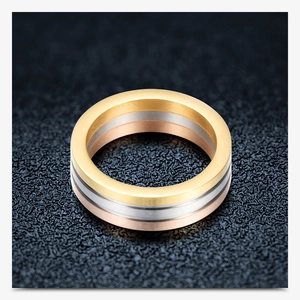Close-up of triple-band stainless steel ring in gold, silver, and rose gold finishes