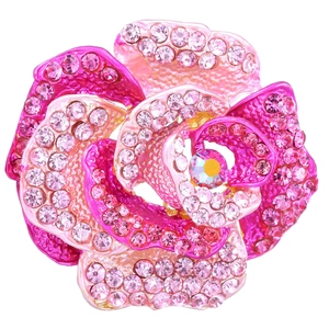 Detailed close-up of a pink rose brooch with layered sparkling crystals and a center gemstone
