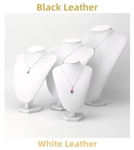 Detail of four silver necklaces with red round gemstone pendants on white bust displays