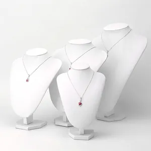 Silver necklace with ruby red stone displayed on elegant white mannequin busts