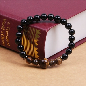 Handmade 8mm black onyx and tiger eye beaded stretch bracelet on a vintage book