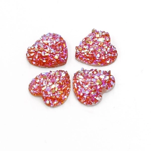 Macro-opname van vier 12mm oranje iriserende hartvormige hars cabochons op witte achtergrond