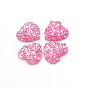 Macro-opname van vier 12mm roze hartvormige glitterhars edelstenen op witte achtergrond