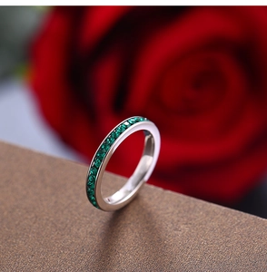 Detailed macro view of silver titanium ring band set with round green zircon stones