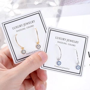 Evil eye stud earrings with pave crystals in gold and silver finishes on display card