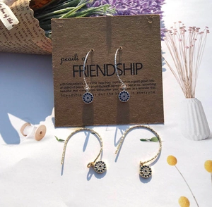 Detailed macro shot of gold and silver Evil Eye drop earrings with blue crystal pavé