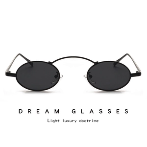 Detail of vintage black oval sunglasses featuring a unique high curved metallic nose bridge
