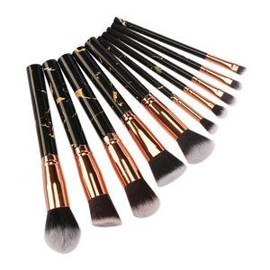 Detail of 10-piece marble makeup brush set with black handles and rose gold ferrules