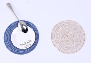 Detailed top-down view of round woven heat-resistant placemats with spiral texture and ceramic plate