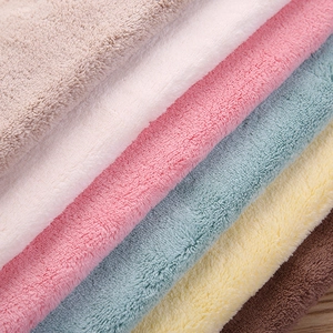 Macro detail of plush coral fleece hand towels in a variety of soft pastel colors