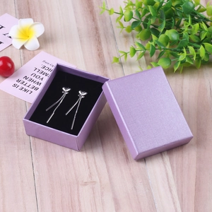 Silver butterfly tassel earrings with purple jewelry gift box on light wood background