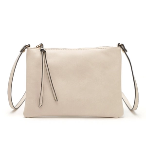 Detail of cream PU leather crossbody bag featuring gold metal hardware and tassels