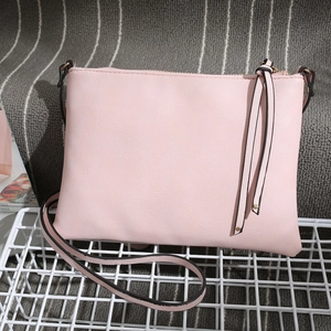 Close-up of pink PU leather envelope crossbody bag with long side fringe detail