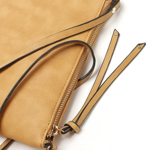 Close-up of beige crossbody bag texture featuring a zipper tassel and gold-tone hardware