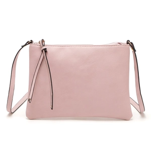 Detailed view of pink PU leather crossbody envelope bag with decorative tassel and strap