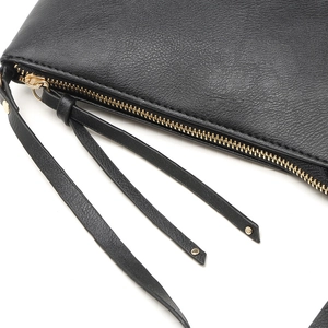 Detailed macro view of black lychee leather bag featuring a smooth zipper and long tassels