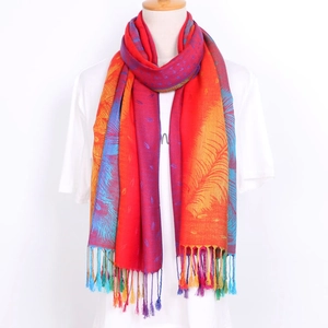 Close-up of ethnic jacquard scarf with colorful peacock feather pattern and soft tassels