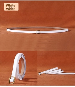 Macro detail of white leather slim belt with a vintage bronze square metal buckle