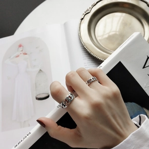 Close-up of 925 sterling silver chain link rings in thick and thin styles on hand