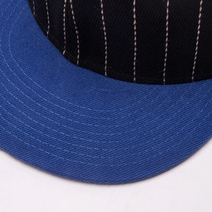 Striped black baseball cap with blue brim featuring reinforced stitching details