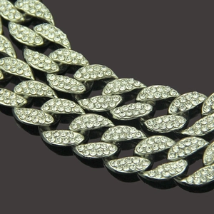 Macro shot of silver hip hop Cuban link chain with sparkling pavé diamond inlay