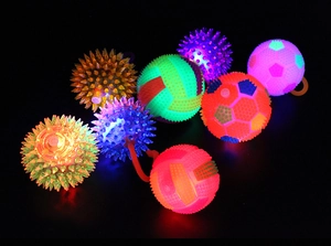 Macro shot of colorful LED glowing spiky balls with rubber texture in a dark setting