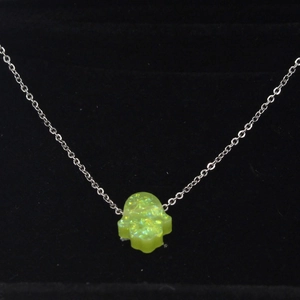 Macro shot of green synthetic opal Hamsa hand pendant necklace on black velvet display