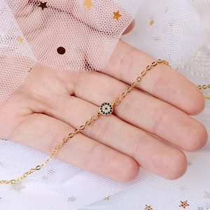 Golden Evil Eye bracelet with blue and white crystals shown on a female wrist