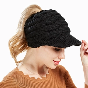 Close-up of black knitted ponytail beanie showing the back opening and thick wool texture
