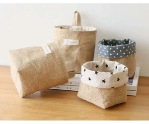 Detail of natural jute hanging storage baskets featuring star and polka dot patterns