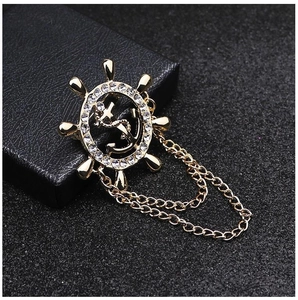 Broche gouvernail nautique dorée avec ancre, strass et double pompon de chaîne fine