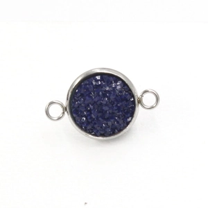 Detail van een ronde roestvrijstalen hanger met donkerblauwe glittersteen inleg