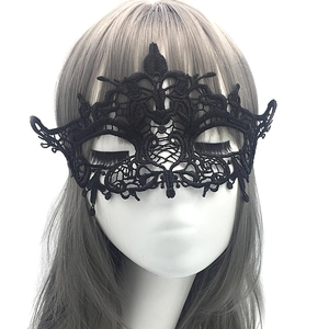 Close-up of black lace masquerade mask with intricate cutout patterns on a white model head