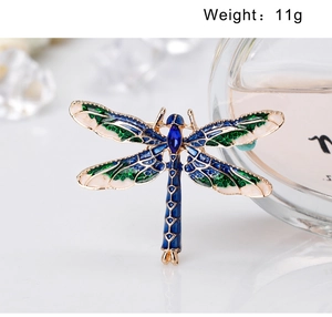 Detail shot of a 11g gold-plated dragonfly brooch with blue enamel wings and gemstones