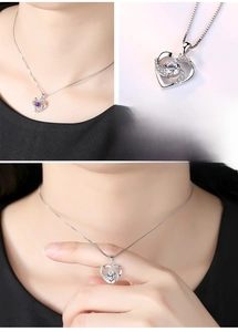 Detail view of a S925 silver heart necklace featuring a rotating clear crystal pendant.