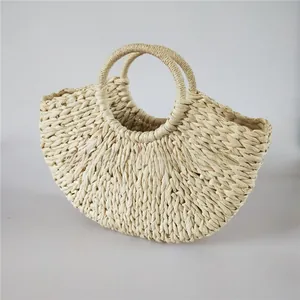 Detail view of handmade cream semi-circle straw tote bag with integrated round handles
