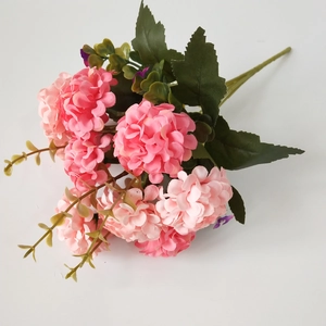 Detailed view of artificial pink hydrangea bouquet with green leaves on white background